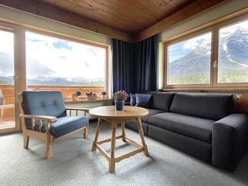 a living room with a couch and a table and windows at Chalet Cristall Superior Appartement 8 in Leutasch