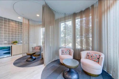 a living room with two chairs and a tv at Modern King Bed Unit with Arcade at The Vic Walk to Midtown Downtown in Houston