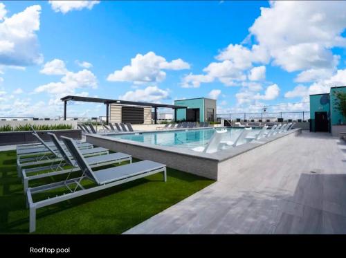 a swimming pool with white lounge chairs on a building at Modern King Bed Unit with Arcade at The Vic Walk to Midtown Downtown in Houston