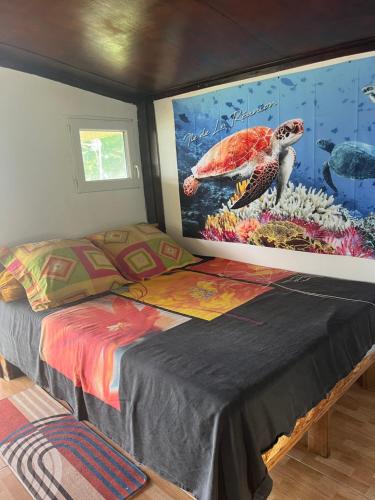 a bedroom with a turtle painting on the wall at Au pied du Piton Bellevue in Sainte-Rose