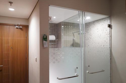 a shower with a glass door in a bathroom at Ramada by Wyndham Yogyakarta in Yogyakarta