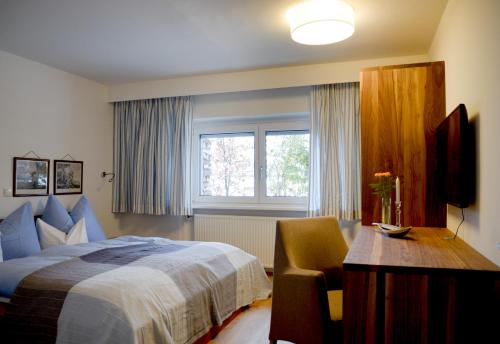 een slaapkamer met een bed, een bureau en een stoel bij Spa & Wellness Apartment Gerda in Grinzens