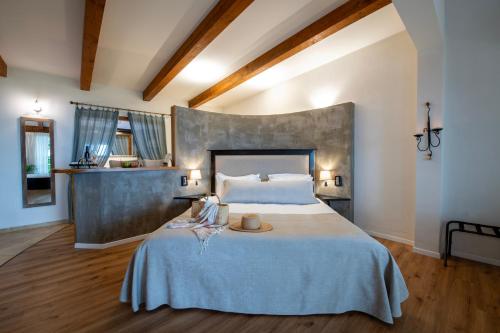 a bedroom with a large bed with a blue blanket at Cnaan Village Boutique Hotel & Spa in Had Nes