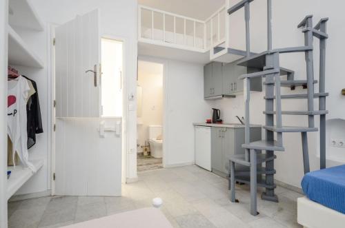a room with a spiral staircase and a bathroom at Depis suites naxos in Naxos Chora