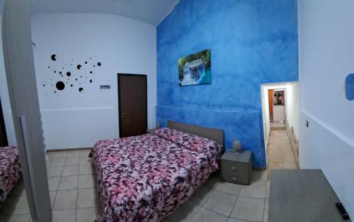 a bedroom with a bed and a blue wall at Casa al Duomo in Augusta
