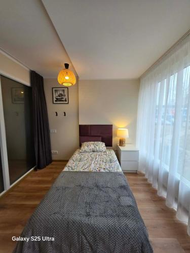 a bedroom with two beds and a window at D20 apartamentai in Mažeikiai