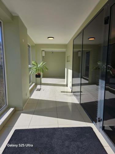 an empty hallway of an office building with a plant at D20 apartamentai in Mažeikiai