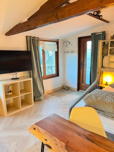 a bedroom with a bunk bed and a wooden table at Grand Studio Cocon & Spa in Mosnay