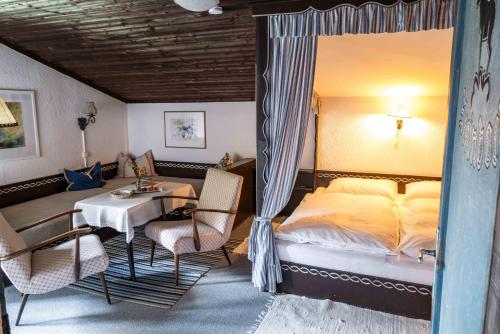 a bedroom with a bed and a table and chairs at Berghotel Blaickner's Sonnalm in Zell am See
