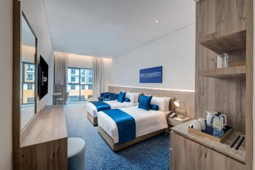 ein Hotelzimmer mit zwei Betten und einem Spiegel in der Unterkunft Kingsgate Hotel Clock Tower in Dubai