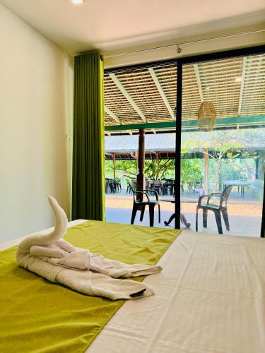 a bedroom with a bed with a towel on it at The Dutch Station Hotel in Ambalangoda