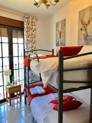 a bedroom with two bunk beds with red pillows at CENTRO ANTEQUERA Apartamento Calzada Centro in Antequera