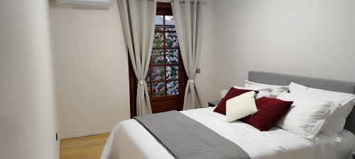 a bedroom with a bed with red and white pillows at abpikermistudios3 in Pikérmion