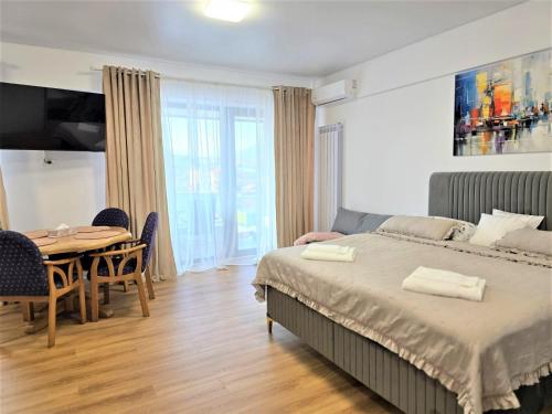 a bedroom with a bed and a table and chairs at Mountain View Studio in Piatra Neamţ
