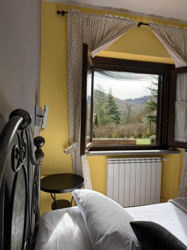 a bedroom with a bed and a window and a table at Tenuta Del Varco in Varco Sabino