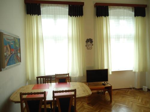 ein Esszimmer mit einem Tisch, Stühlen und Fenstern in der Unterkunft Apartment Harmonia in Franzensbad