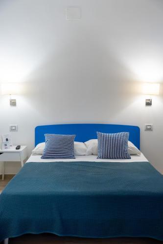 a blue bed with two pillows in a bedroom at The Garden in Pulsano