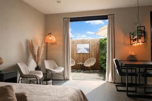 a bedroom with a door open to a patio with a table and chairs at Studio Isleña in Vlissingen