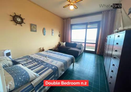 a bedroom with a bed and a couch at Bergeggi - Appartamento Fronte Mare in Bergeggi