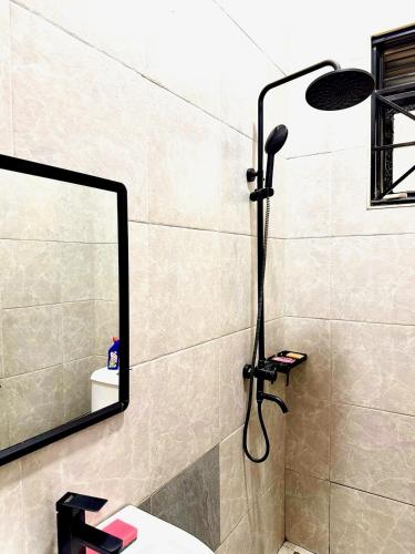a shower in a bathroom with a mirror at Sky world homes in Kampala