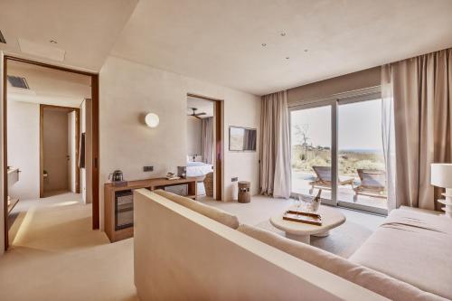 a living room with a couch and a large window at Ovea Paros in Naousa