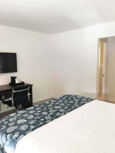 a bedroom with a bed and a desk and a television at Diablo Mountain Inn Walnut Creek in Walnut Creek