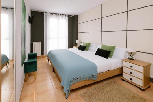 a bedroom with a large bed and a chair at Amari in Getaria
