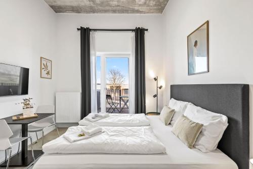 a bedroom with two beds and a table and a window at SKYRISE Apartments mit Küche, WLAN & Parkplatz - ruhige Lage in Bad Wörishofen