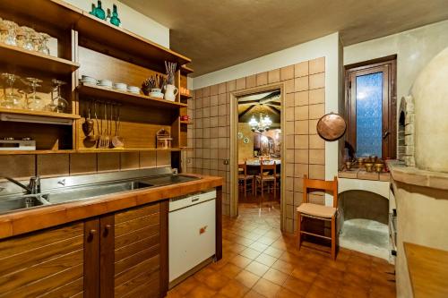 a kitchen with a sink and a counter with a table at Villa La Fortezza in Dormelletto