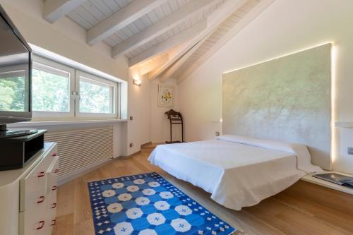 a bedroom with a white bed and a large window at Villa La Fortezza in Dormelletto