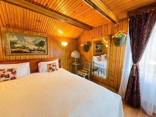 a bedroom with a white bed in a wooden room at SemiLuna in Buşteni