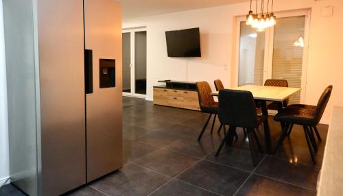 a dining room with a table and a refrigerator at Monteurunterkunft Lüneburg bis 18 Personen drei Häuser nebeneinander Parkplatz WLAN in Artlenburg