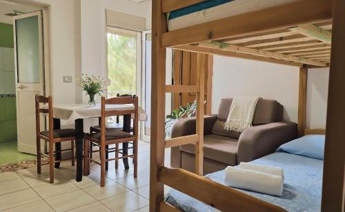 a room with a bed and a dining room with a table at Hotel Gonaj in Velipojë