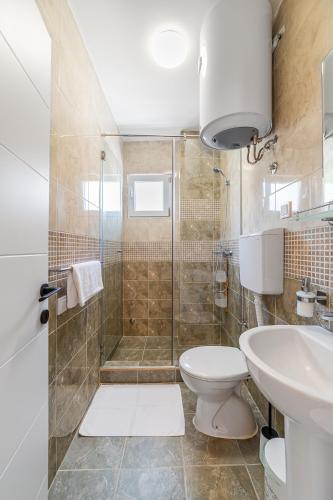 a bathroom with a shower and a toilet and a sink at Relaxing 2 bedroom apartment with Bay View and Parking in Prčanj
