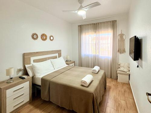 a bedroom with a large bed and a television at Casa de playa, cerca de todo in Los Narejos