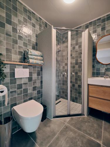 a bathroom with a shower and a toilet and a sink at B&B 't Herfter Erf in Zwolle