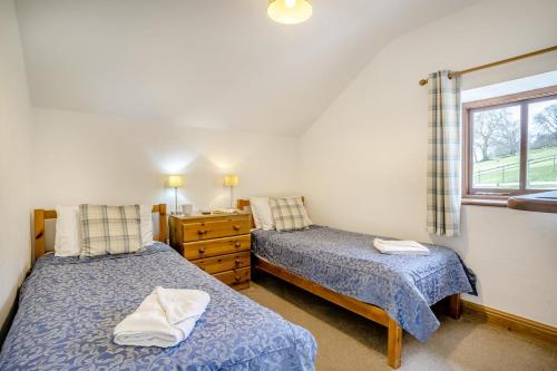 a bedroom with two beds and a dresser and a window at 2 Bed in Risca oc-b35977 in Risca