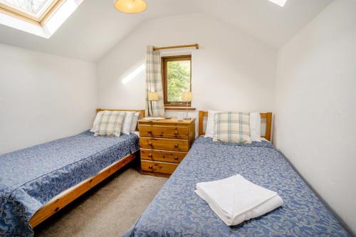 a bedroom with two beds and a dresser and a window at 2 Bed in Risca oc-h35978 in Risca