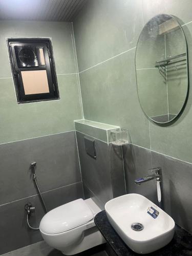 a bathroom with a white toilet and a mirror at Bachelor Stay - CBD Belapur in Navi Mumbai