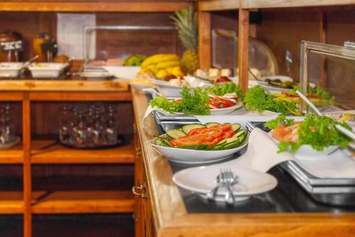 a buffet line with several plates of vegetables and fruit at Hotel Aviv Dresden in Dresden