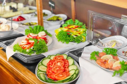 a buffet with plates of food on a table at Hotel Aviv Dresden in Dresden