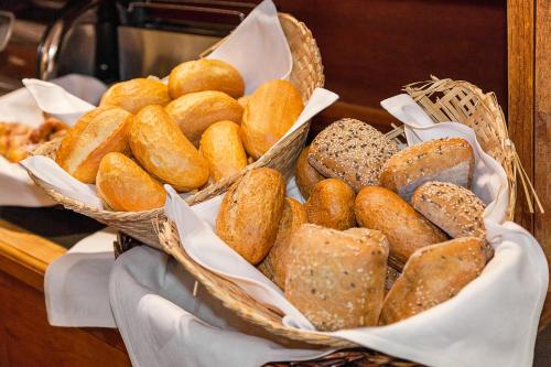 a bunch of baskets filled with different types of bread at Hotel Aviv Dresden in Dresden