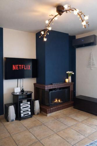 a living room with a fireplace and a blue wall at Derveni Seaside Apartments - Deluxe Sea View Penthouse Jacuzzi-BBQ & Groundfloor Garden View Apartment in Derveni