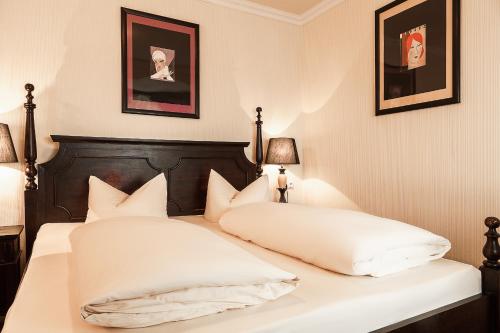 a bedroom with a bed with white pillows at Hotel Aviv Dresden in Dresden