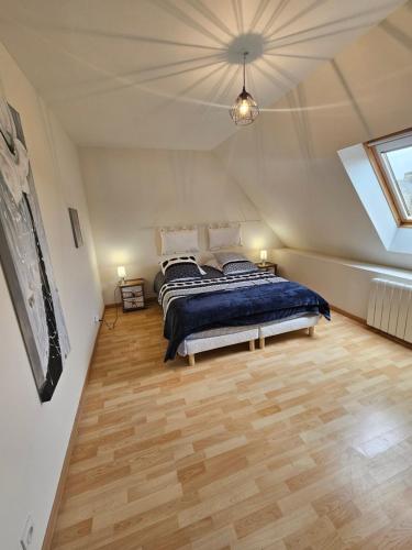 a bedroom with a bed and a wooden floor at gîte Brocéliande - Harmonie et tranquillité près de la mer in Theix