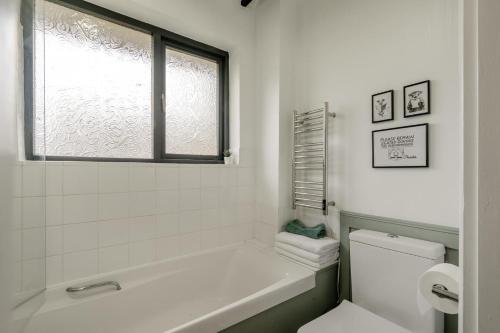 a bathroom with a tub and a toilet and a window at 2 Bed in Beaconsfield oc-t35951 in Beaconsfield