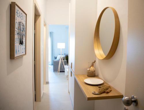a bathroom with a sink and a mirror on the wall at Infinite Blue Suites in Agia Marina Aegina
