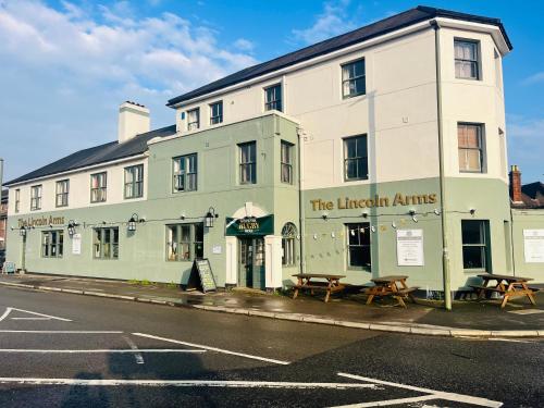 a large white building on the corner of a street at The Lincoln Arms in Dorking