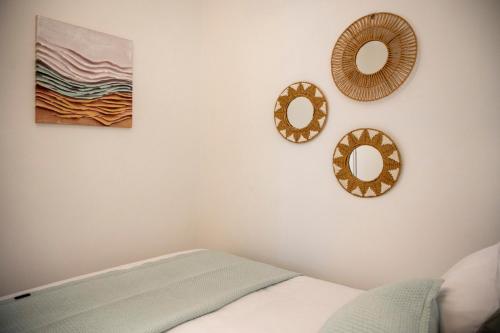 a bedroom with two mirrors on the wall and a bed at Infinite Blue Suites in Agia Marina Aegina
