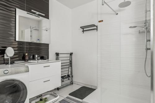 a bathroom with a washing machine and a shower at NK Apartment in Bobigny in Bobigny